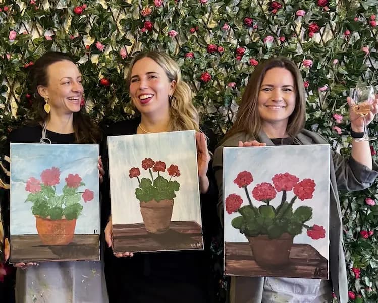 Netler ladies holding paintings during team building